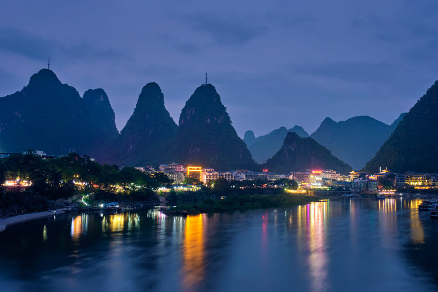 la ciudad de yangsdhuo al anochecer con las montañas de fondo